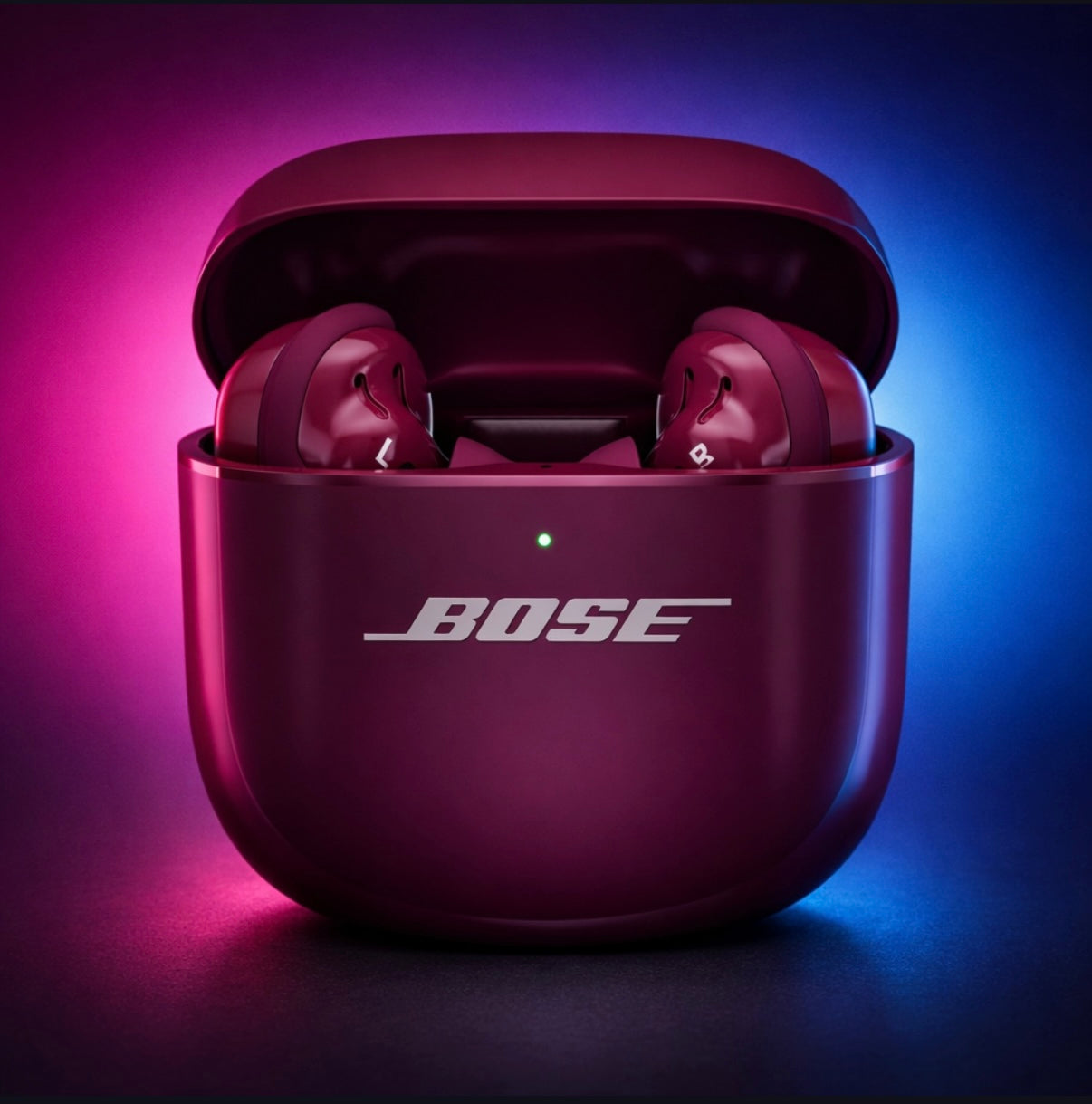 Bose wireless earbuds in a maroon case on a two-tone purple and blue background