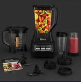 Ninja BL770 blender and food processor with various containers, cups, and recipe book showcasing colorful fruit blend.