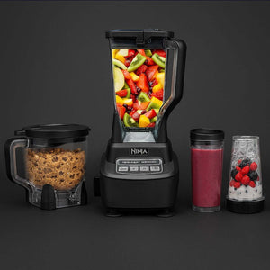 Ninja BL770 Blender with fresh fruits, food processor bowl, and smoothie cups on a dark background.